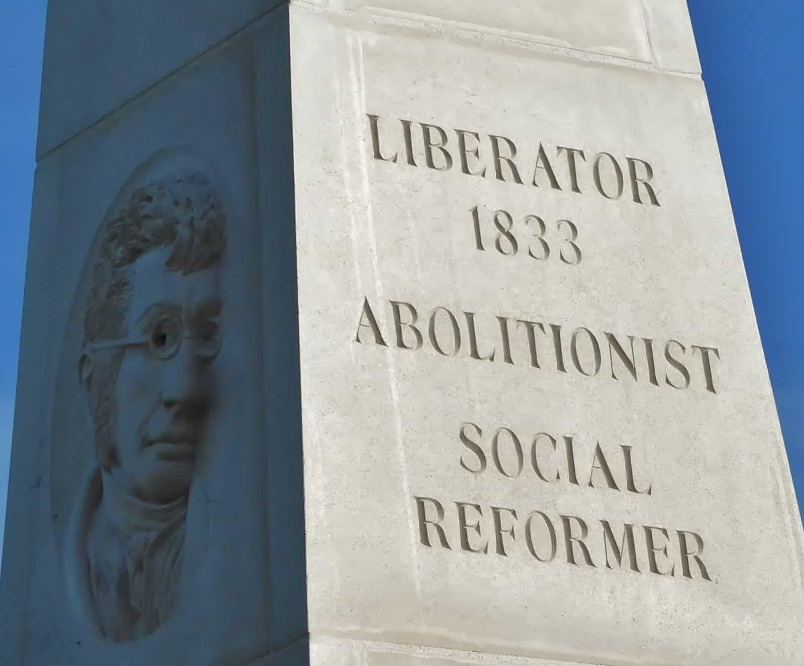 Bas-relief profile of a historical figure on a monument, with the words "liberator 1833 abolitionist social reformer" engraved beside it.